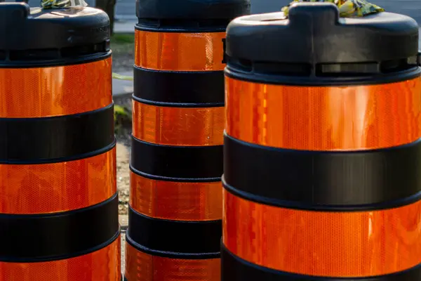 Barriles de tráfico de plástico rayado naranja y negro en una zona de construcción de carreteras —  Fotos de Stock