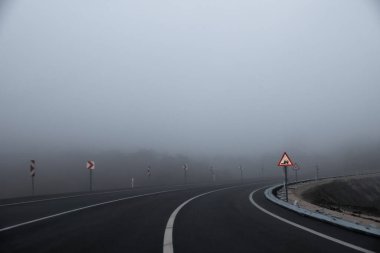 Sisli, sisli yol ve trafik işaretleri.