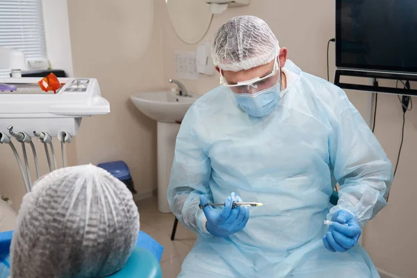 Tandläkare gör lokalbedövning skott före operation. Patientbesök på tandläkarmottagning — Stockfoto