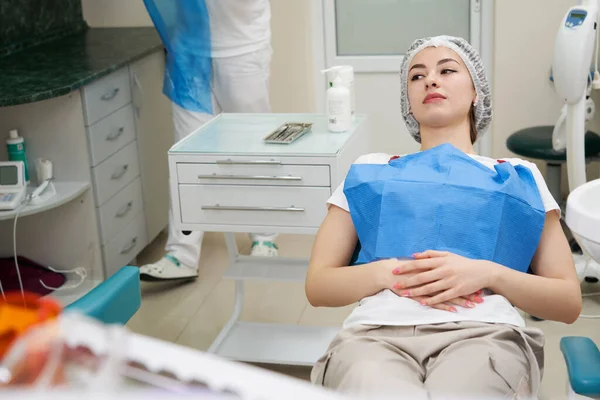 Yong söt kvinna sitter i tandläkarstolen på tandläkarmottagningen, Kvinna patient på tandläkaren väntar på att kontrolleras — Stockfoto