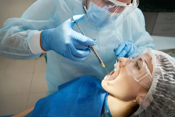 Dentista a fazer anestesia local antes da cirurgia. Paciente visitando um consultório odontológico — Fotografia de Stock