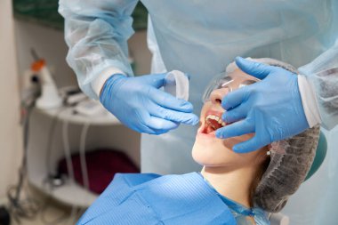 Dişçi modern diş kliniğindeki hastalar için kauçuk genişletici kullanıyor.