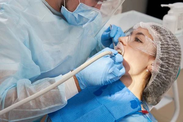 Tandläkare borra tand till manlig patient i tandstolen — Stockfoto
