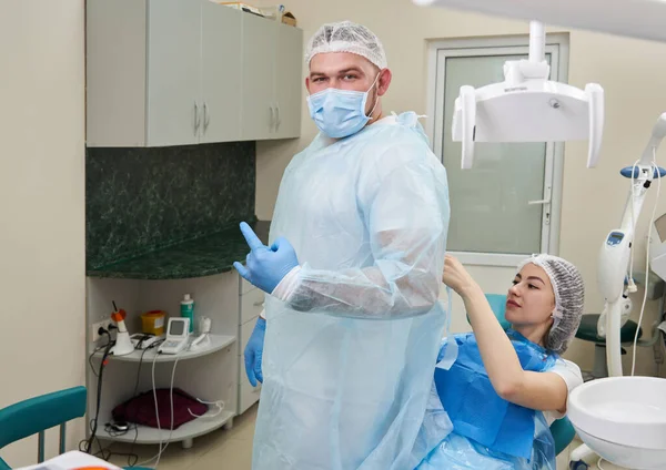 帮助牙医在牙科诊所穿制服的病人 — 图库照片