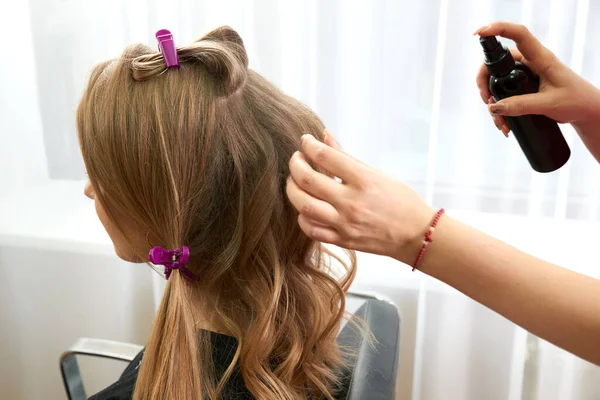 Парикмахер-распылитель волос молодой женщины в салоне красоты — стоковое фото