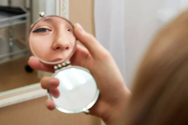 Fiatal nő arc tükröződés egy kis tükörben — Stock Fotó