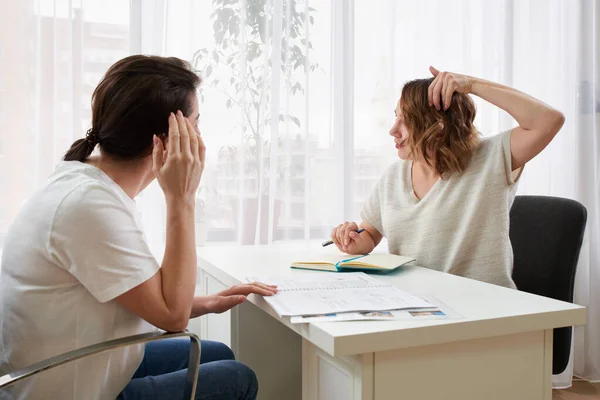 Médico o especialista en masajes consultando a una joven sobre dolor de cabeza — Foto de Stock