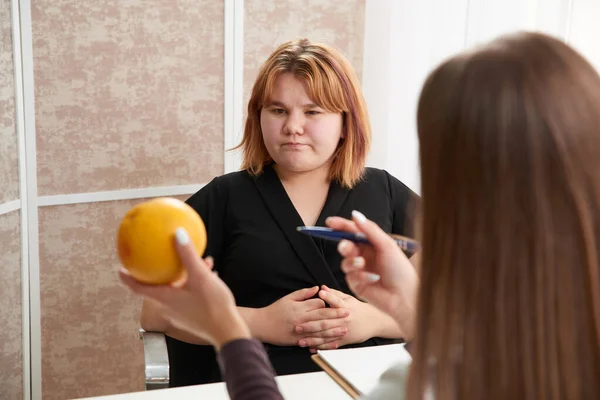 Jovem mulher com sobrepeso visitando nutricionista para perder peso com a ajuda da dieta — Fotografia de Stock