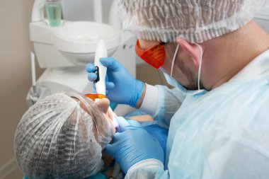 Klinikte diş hekimi ultraviyole ışığı tedavi ediyor.