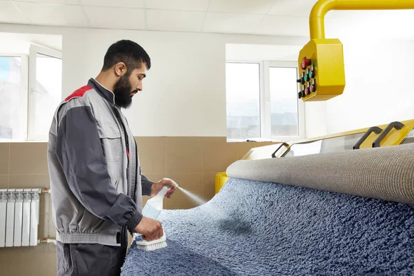 Detergente de pulverización de hombre en alfombra gris para eliminar manchas en el servicio de limpieza profesional —  Fotos de Stock