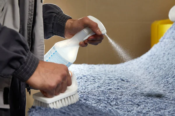 Detergente spray uomo sul tappeto grigio per rimuovere la macchia nel servizio di pulizia professionale — Foto Stock