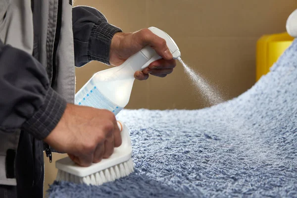 Hombre usando spray para eliminar manchas de la alfombra en el servicio de limpieza de alfombras —  Fotos de Stock