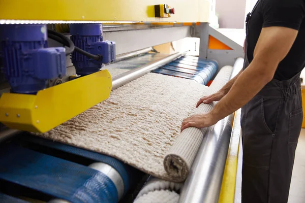 Pekerja laki-laki membersihkan karpet pada peralatan mesin cuci otomatis dan pengering di ruang cuci. layanan cuci profesional — Stok Foto