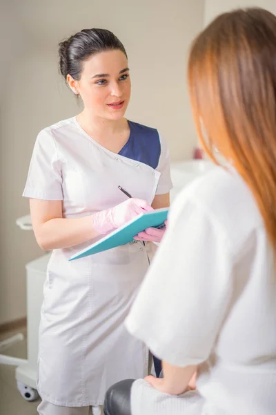 Mujer paciente y médico tienen consulta en clínica médica, escribir notas — Foto de Stock