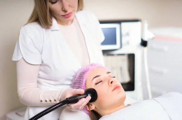 Young woman receiving treatment in cosmetology clinic. Cosmetology skin care. Aesthetic facial treatment Concept. — Stock Photo, Image