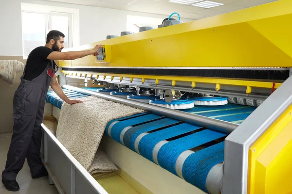 Человек работает ковер автоматическая стиральная машина в профессиональной прачечной — стоковое фото