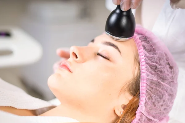 Young woman receiving treatment in cosmetology clinic. Cosmetology skin care. Aesthetic facial treatment Concept.