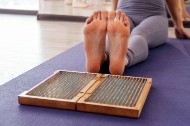 Ayaklar ve tahta tahta, keskin metal çiviler. Sadhu ayak tahtası. Yoga gevşeme alıştırması eğitimi