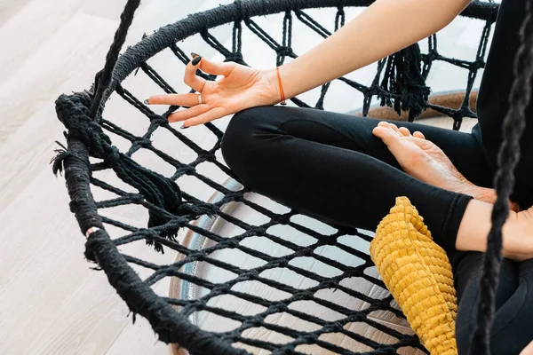 stock image Close up of yoga girl sitting in lotus asana on hammock during yoga class, cropped view