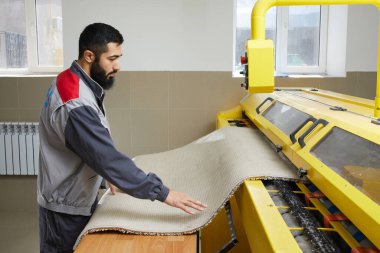 Profesyonel çamaşır servisinde otomatik çamaşır makinesi kullanan bir adam.