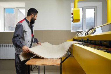 Profesyonel çamaşır servisinde otomatik çamaşır makinesi kullanan bir adam.