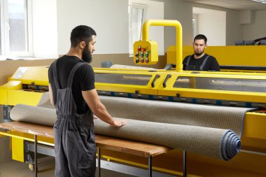 Çamaşır yıkama servisinde profesyonel temizlik ekipmanı kullanan iki adam.