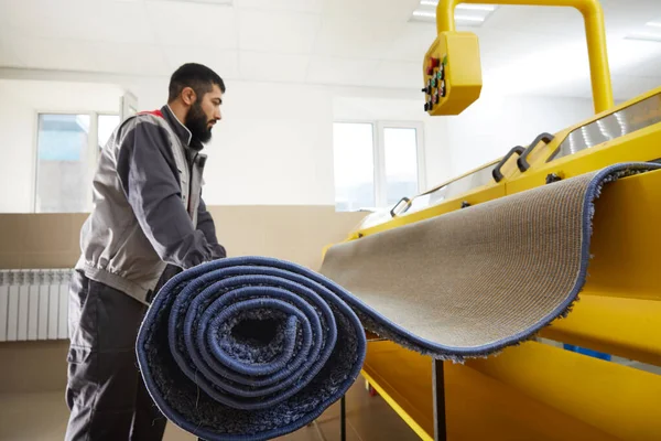 Hombre que opera la máquina de limpieza automática de alfombras en el servicio de lavandería profesional —  Fotos de Stock