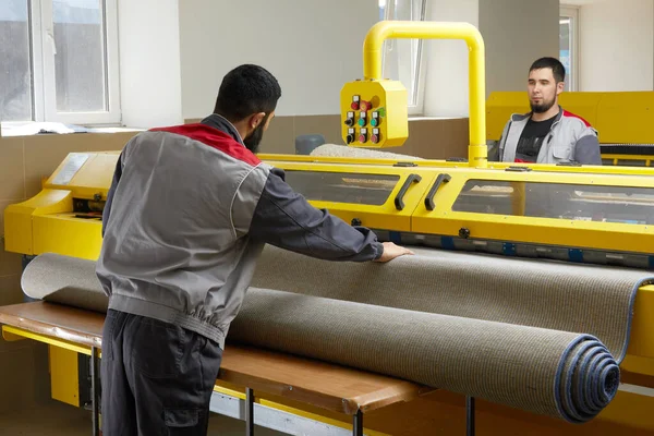 Двое мужчин, работающих с профессиональным оборудованием для уборки ковров в прачечной — стоковое фото