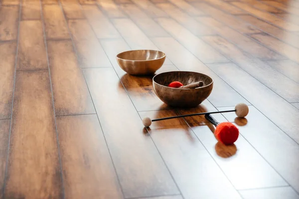 Tibetan handcrafted singing bowls on the floor in yoga class, sound therapy concept — Stock Photo, Image