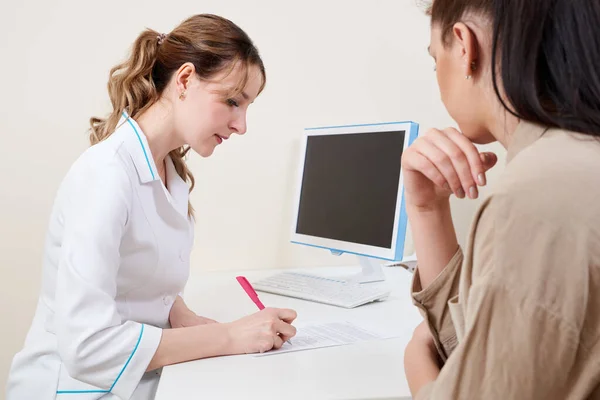 Doctor prescribes medication to young female patient