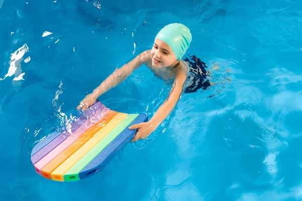 Lekcje pływania. Zbliżenie dzieci ćwiczących trzepotanie kopniaka z deską kopniaka w basenie — Zdjęcie stockowe