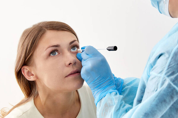 Doctor taking sample with swab from the eye