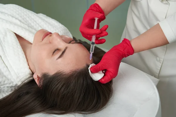 Médico de beleza faz injeções de beleza de rejuvenescimento de ácido hialurônico na cabeça de bela jovem paciente para o crescimento do cabelo e para evitar a ousadia — Fotografia de Stock