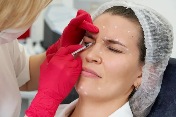 女人的面部注射正在恢复活力。美容师正在用透明质酸填补女性皱纹 — 图库照片