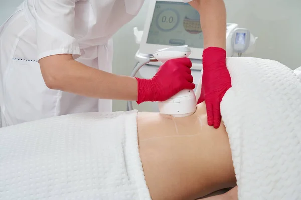 Professionele cosmetoloog uitvoeren van radiofrequentie tillen procedure op de maag van een vrouw — Stockfoto