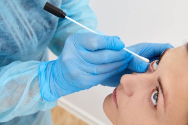 Doktor gözünden numune alıyor.