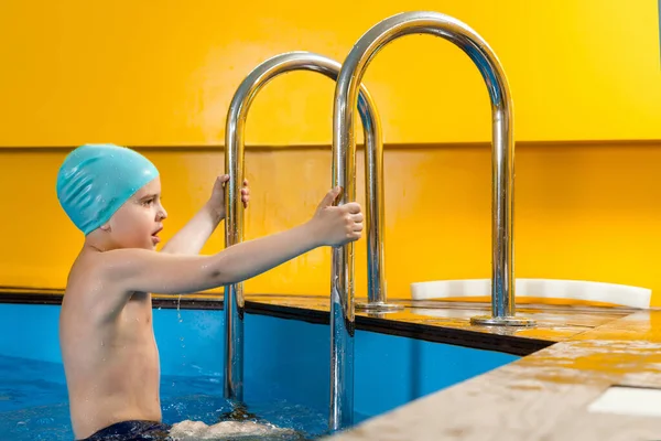 Chłopiec pływanie w krytym basenie zabawy podczas lekcji pływania — Zdjęcie stockowe