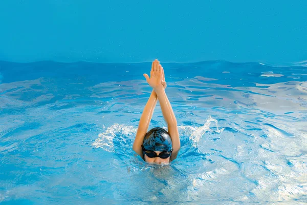 Niño nadando en piscina cubierta divirtiéndose durante la clase de natación —  Fotos de Stock