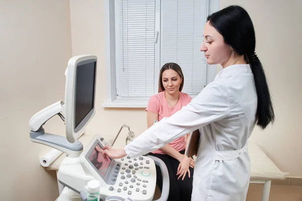 Gynekolog gör ultraljudsundersökning på modern klinik och visar resultat på skärmen — Stockfoto