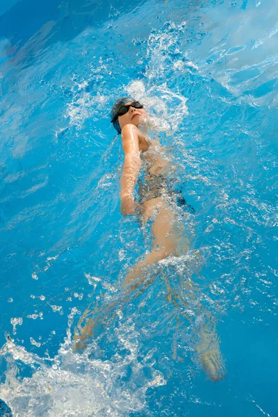 Chłopiec pływanie w krytym basenie zabawy podczas lekcji pływania — Zdjęcie stockowe