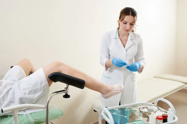 Gynaecoloog die een patiënt onderzoekt die op een gynaecologische stoel zit — Stockfoto