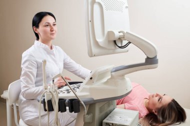 Jinekolog modern klinikte ultrason taraması yapıyor.
