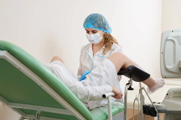 Gynekolog undersöker en patient som sitter på en gynekologisk stol — Stockfoto