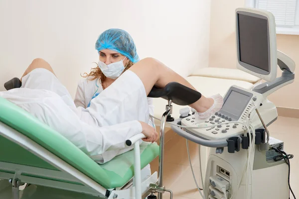 Gynekolog undersöker en patient som sitter på en gynekologisk stol — Stockfoto