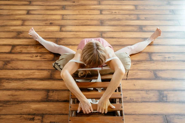 Зрелая женщина делает упражнения по растяжке на скамейке в студии — стоковое фото