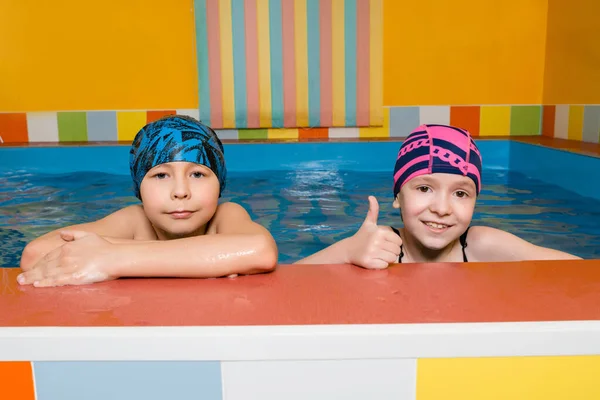 Portret kaukaskiego chłopca i dziewczynki w basenie — Zdjęcie stockowe