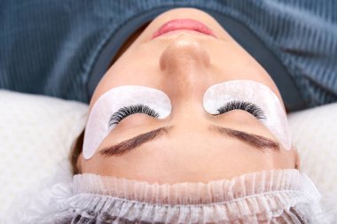 Güzellik salonunda uzun kirpikleri olan güzel bir kadın. Kirpik uzatma işlemi