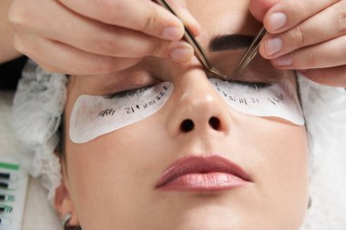 Kirpik uzatma prosedürünü kapat. Güzellik salonunda uzun kirpikleri olan güzel bir kadın