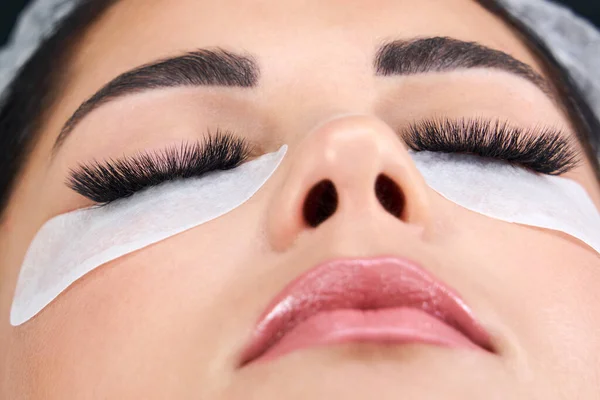 Wanita cantik dengan bulu mata panjang di salon kecantikan. Prosedur ekstensi eyelash — Stok Foto