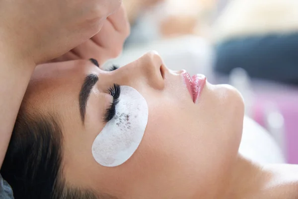 Procédure d'extension des cils avec pince à épiler dans le salon de beauté — Photo